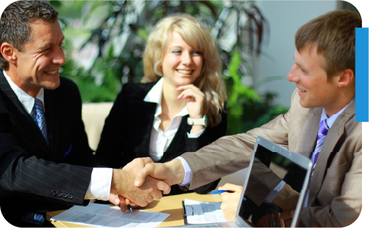 Two business professionals shaking hands during a meeting, symbolizing successful insurance agency sales negotiation.